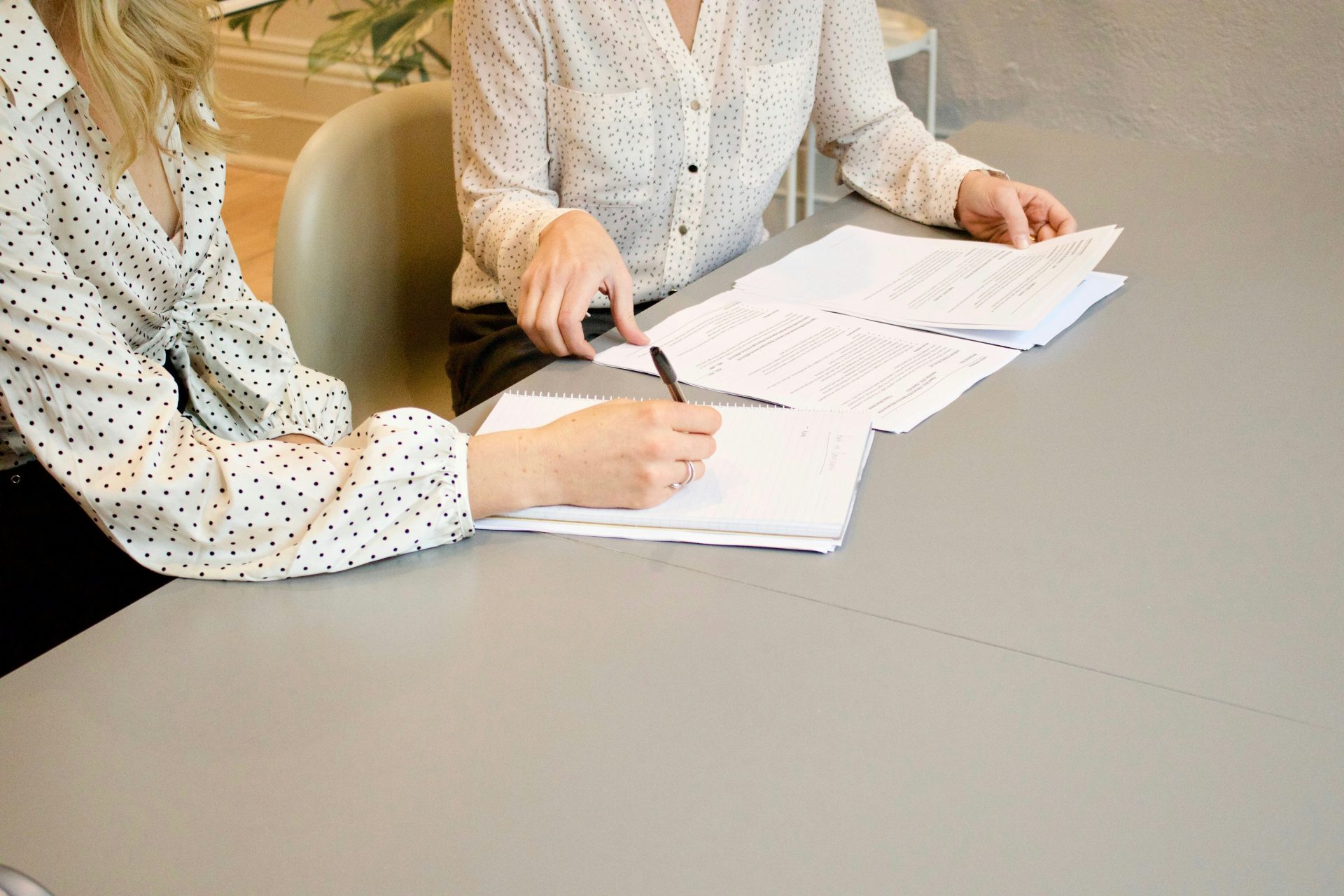 2 professional women signing papers